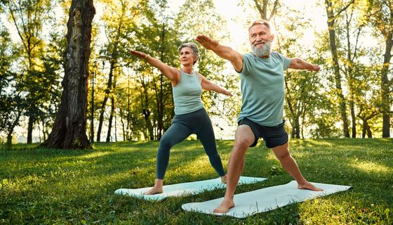 Zwei Senioren, trainieren Yoga im Park.