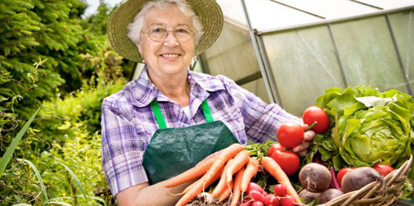 Ältere Frau mit Gemüsekorb