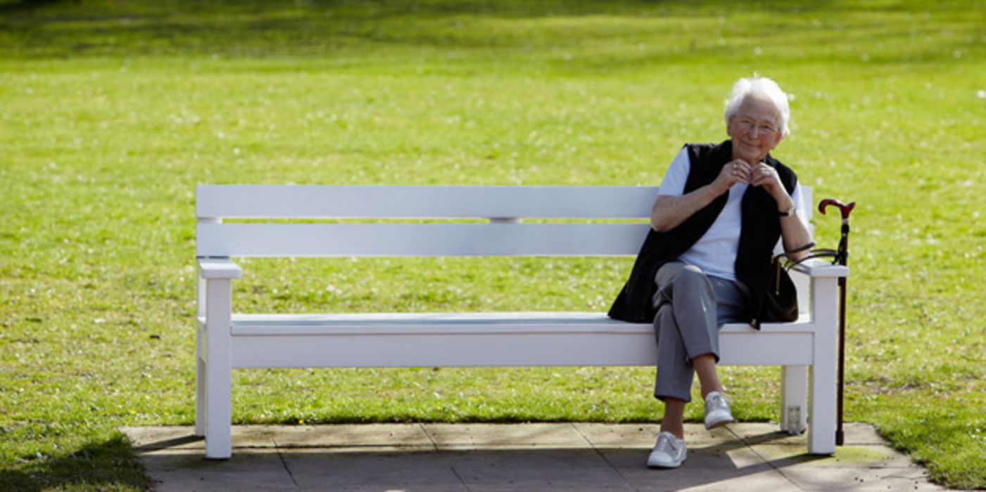 Alte Frau auf einer Parkbank