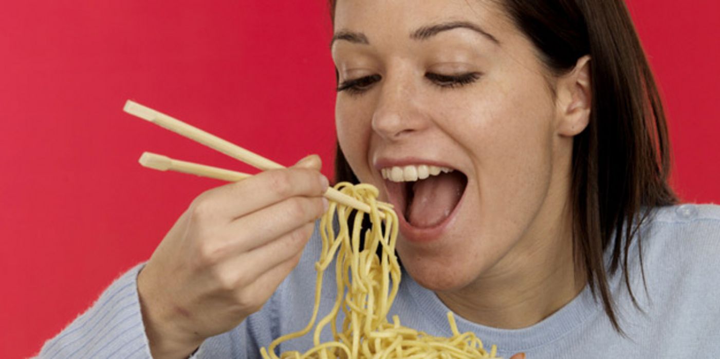 Junge Frau verschlingt eine Portion Spaghetti