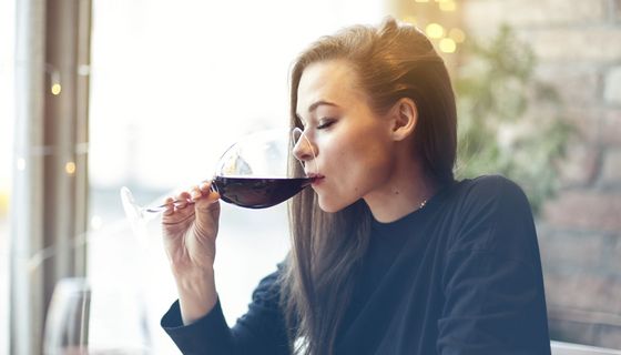 Frau trinkt ein Glas Rotwein.