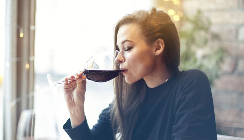 Frau trinkt ein Glas Rotwein.