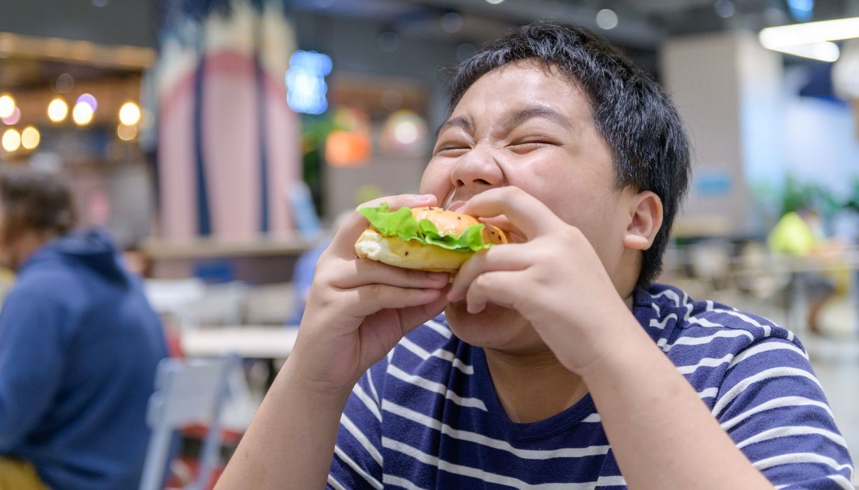 Übergewichtiger Jugendlicher mit Hamburger.