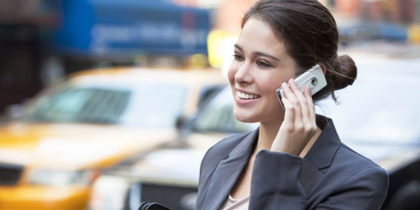 Junge Frau im Stadtverkehr telefoniert mit Handy