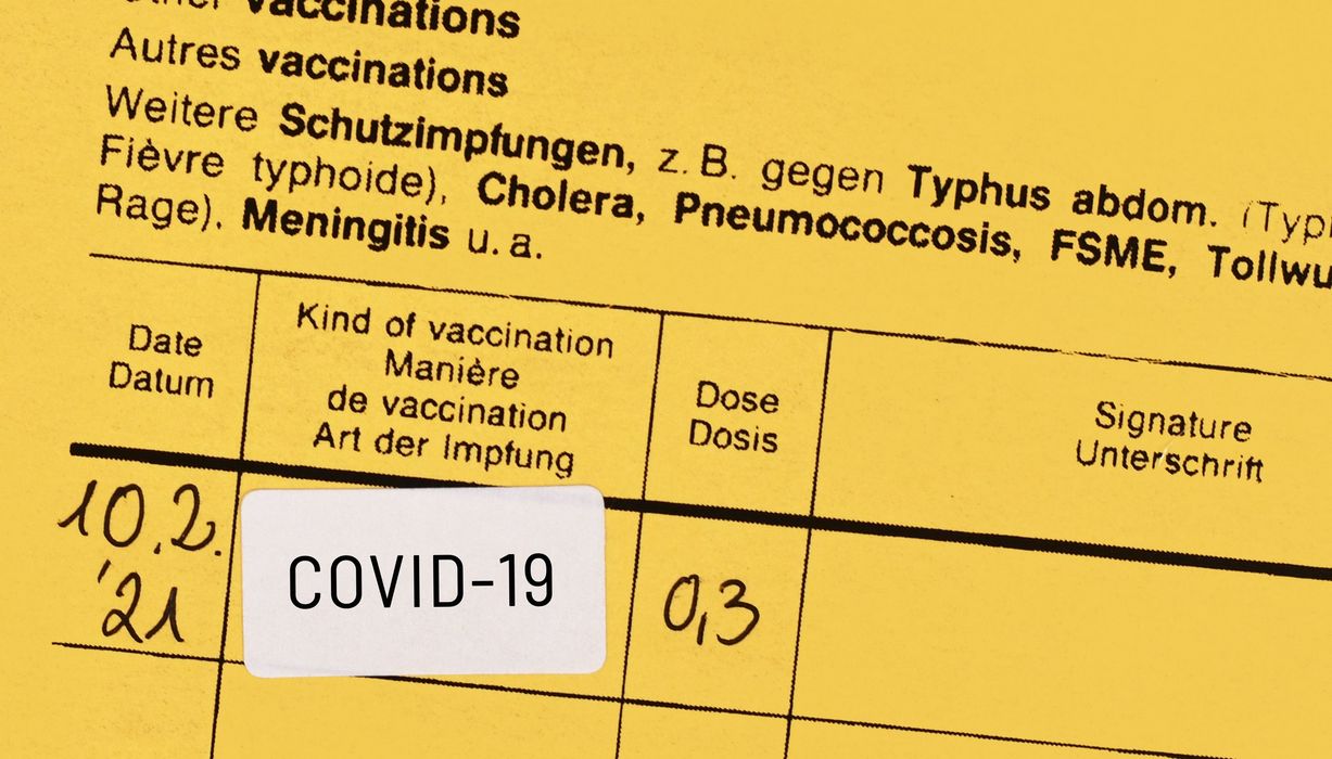 Gelbes Impfbuch mit bestätigter Covid-19-Impfung.