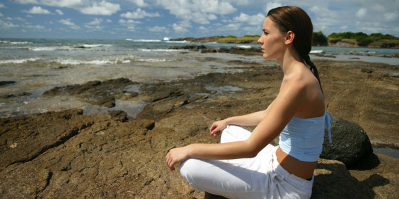 Meditierende Frau an der Küste