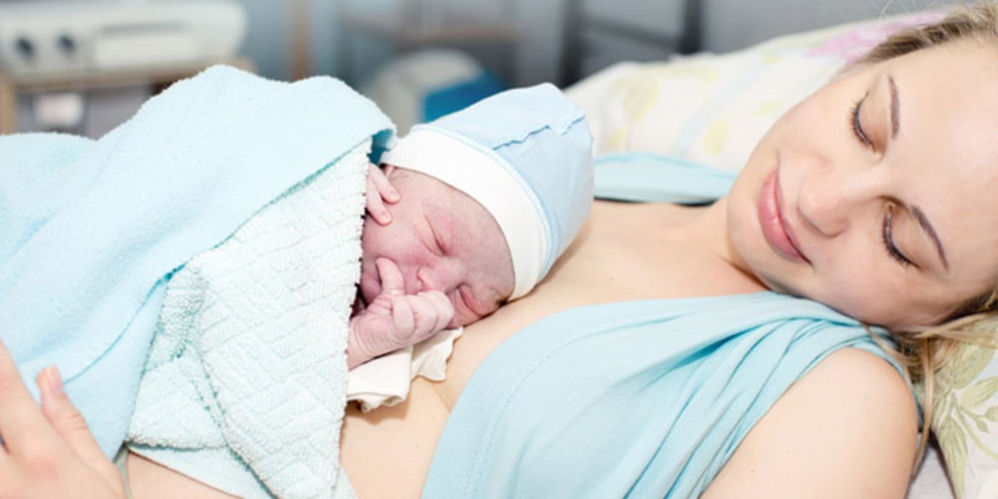 Frau mit Neugeborenem auf dem Bauch