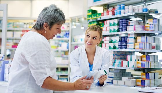Apothekerin berät Kundin zu Arzneimitteln.