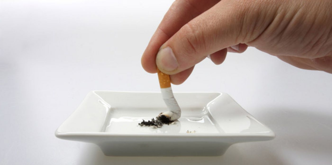 Zigarette wird in Aschenbecher zerdrückt.