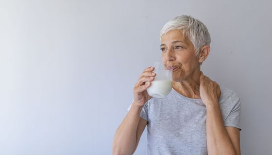 Ältere Frau, trinkt ein Glas Milch.