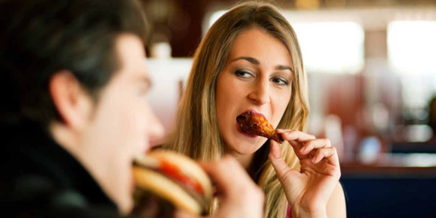 Mann und Frau essen Fast Food.