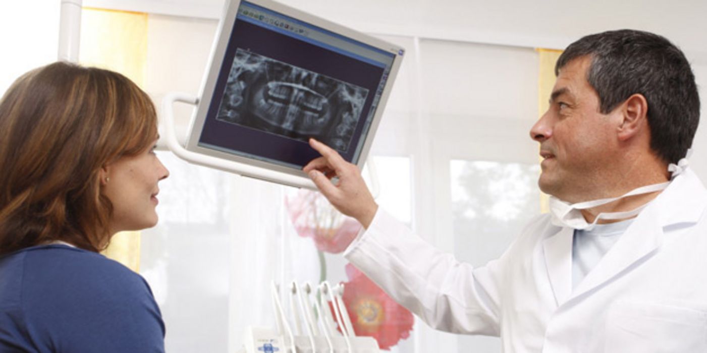 Zahnarzt erklärt Patientin ihr Röntgenbild