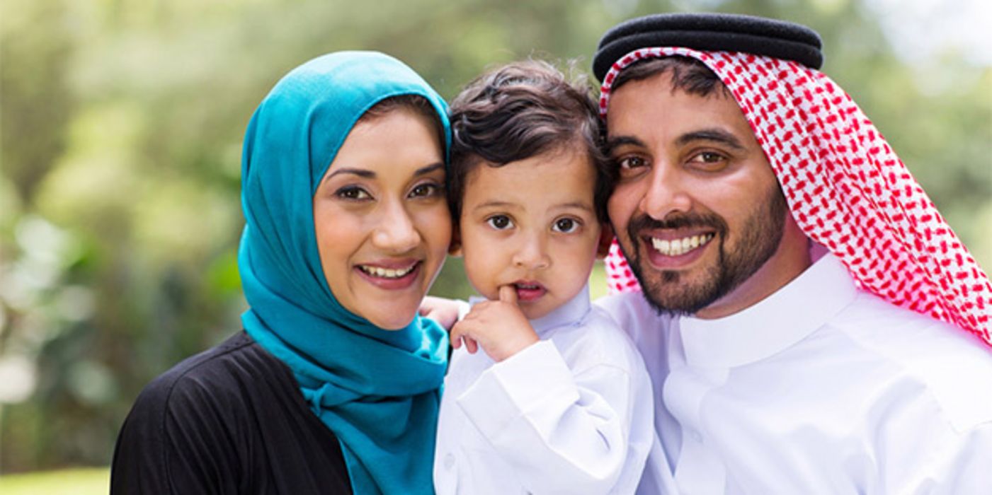 Saudi-Arabisches Ehepaar mit kleinem Kind, ca. 2 Jahre, in der Mitte, Eltern lächeln in Kamera