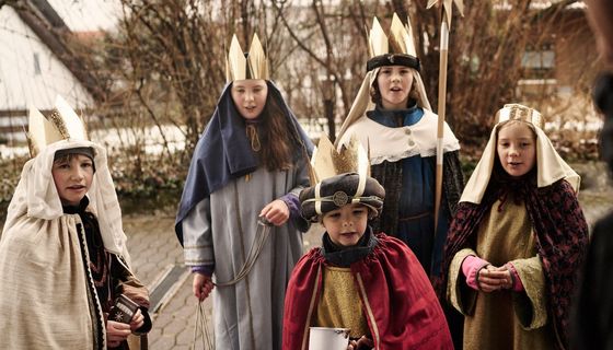 Gruppe von Sternsingern an der Haustür