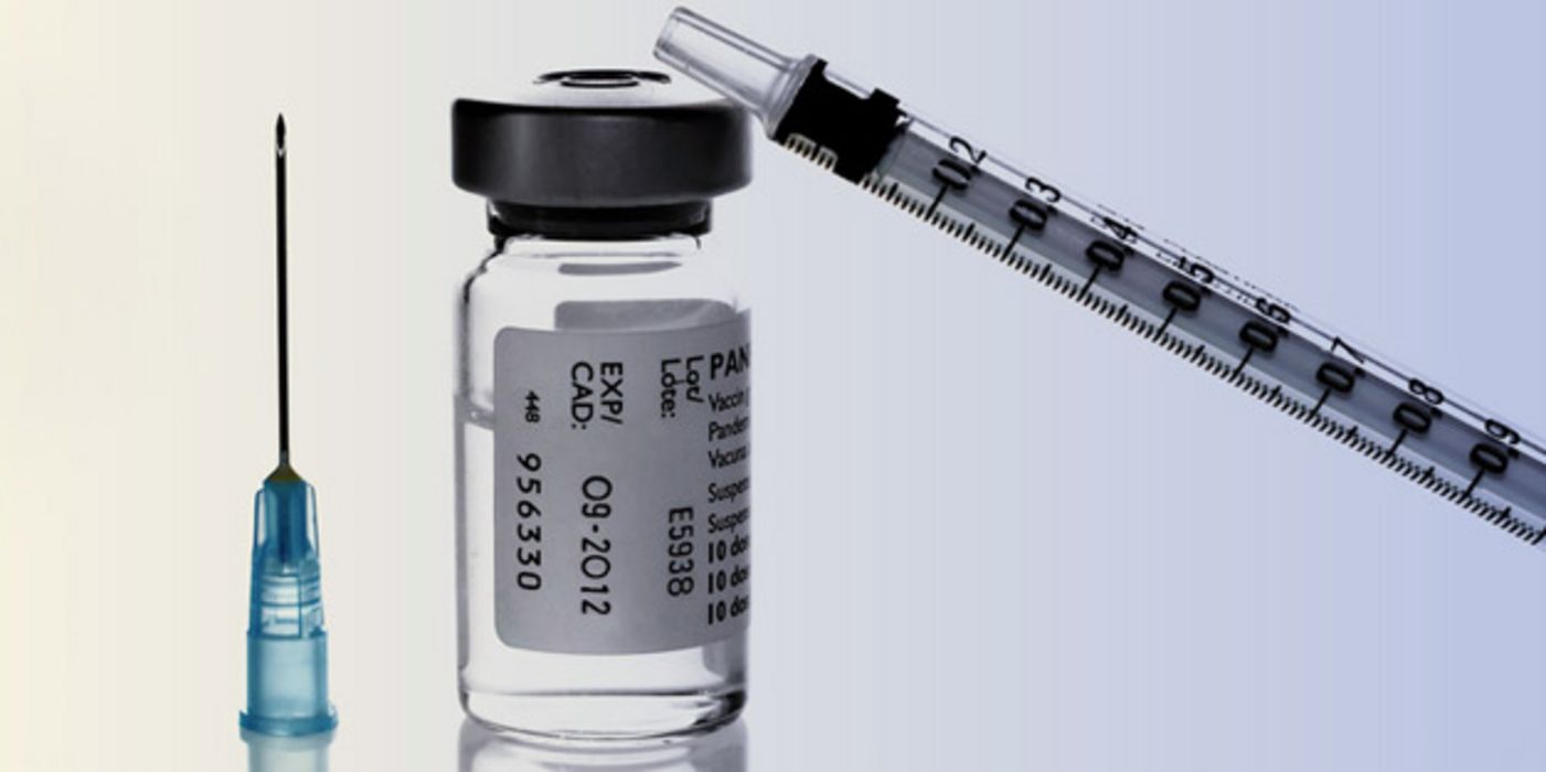 Ampulle mit Grippe-Impfstoff und Spritze