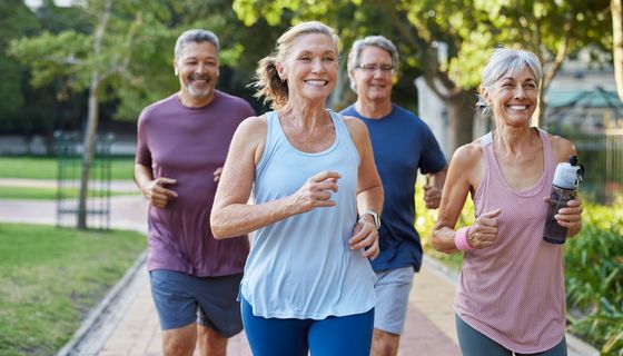 Gesunde Seniorengruppe joggt gemeinsam im Park