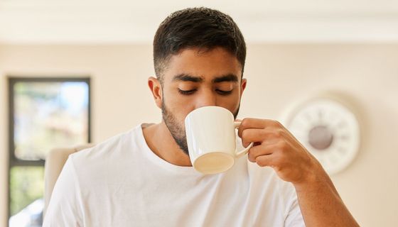Junger Mann trinkt eine Tasse Kaffee.