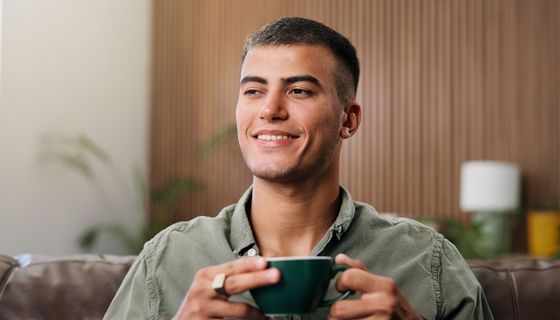 Junger Mann trinkt eine Tasse Tee.