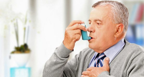 Älterer Herr inhaliert ein Asthma-Spray