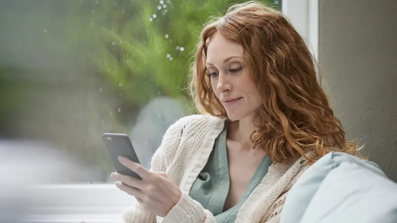 Frau, schaut auf ihr Smartphone.