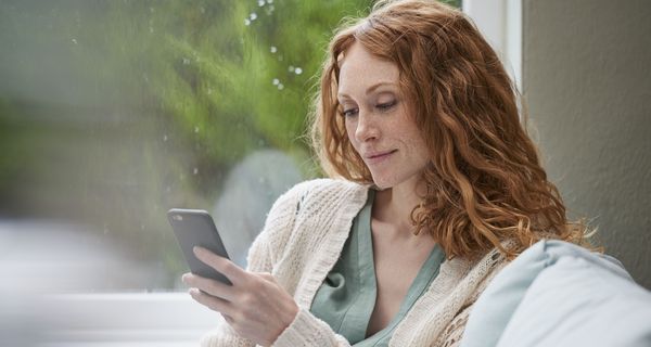 Frau, schaut auf ihr Smartphone.