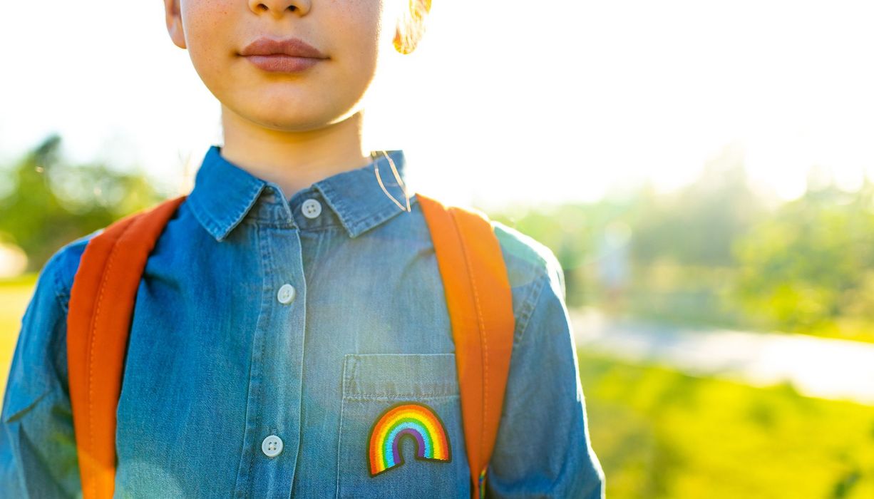 Jugendliche mit Regenbogen-Print auf dem Oberteil.