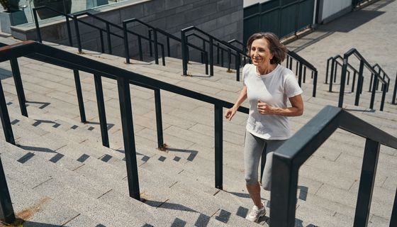Frau, joggt eine Treppe hoch.