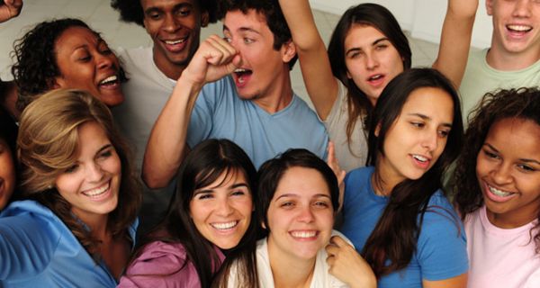 Gruppe attraktiver junger multikultureller Menschen schauen nach oben lachend in die Kamera