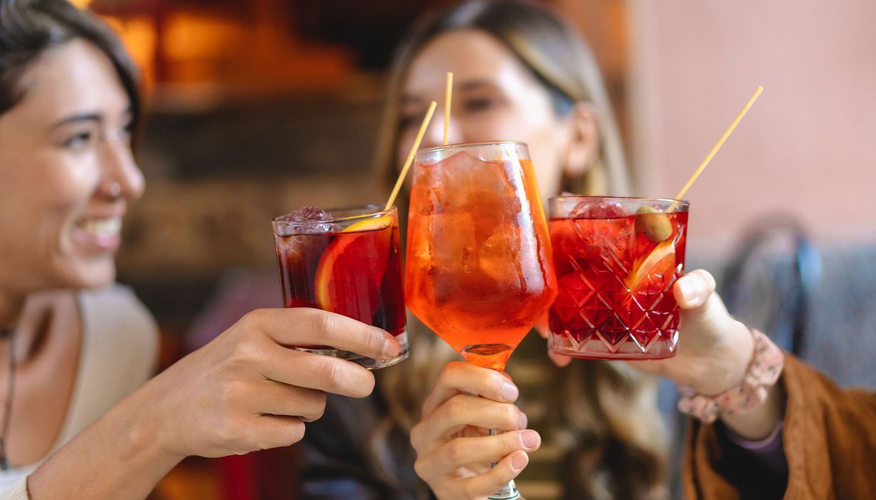 Frauen stoßen mit alkoholischen Getränken an.