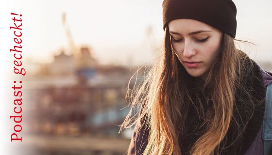 Junge Frau, schaut traurig nach unten.