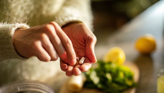 Frau, hat zwei Tabletten in der Hand.