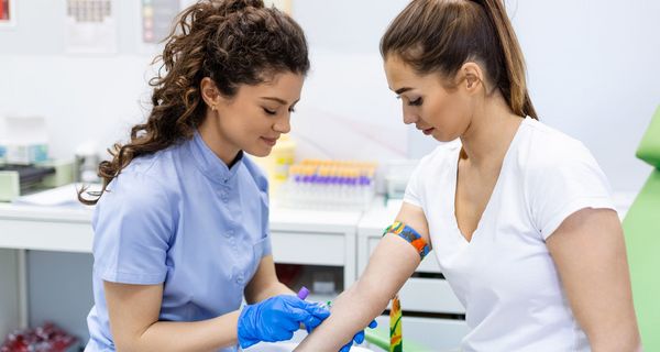 Medizinisches Fachpersonal nimmt einer Patientin Blut ab.