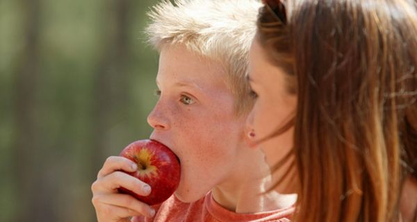 Junge isst Apfel.