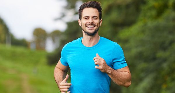 Ein Mann joggt im Grünen.