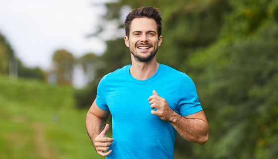 Ein Mann joggt im Grünen.