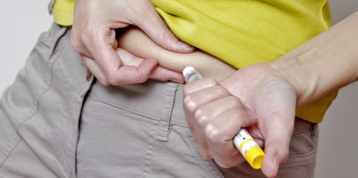 Frau spritzt sich Insulin in eine Bauchfalte