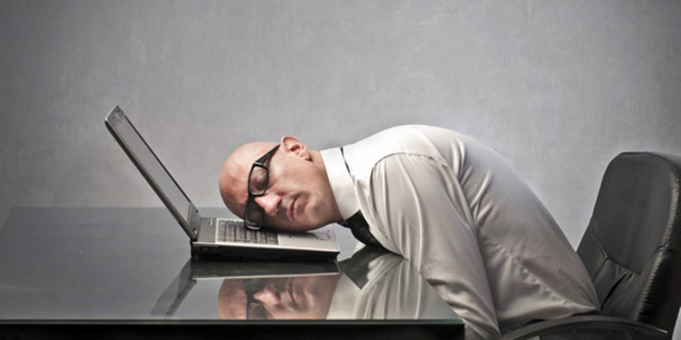 Büroszene, glatzköpfiger Angestellter, Schlips, weißes Hemd, Brille mit dunklem Rand, schläft mit der einen Wange auf dem Laptop