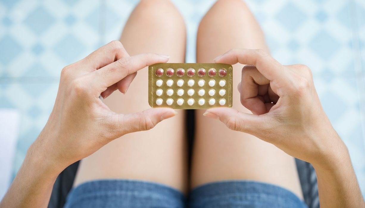 Frau, hält Blister mit Antibabypille in der Hand.