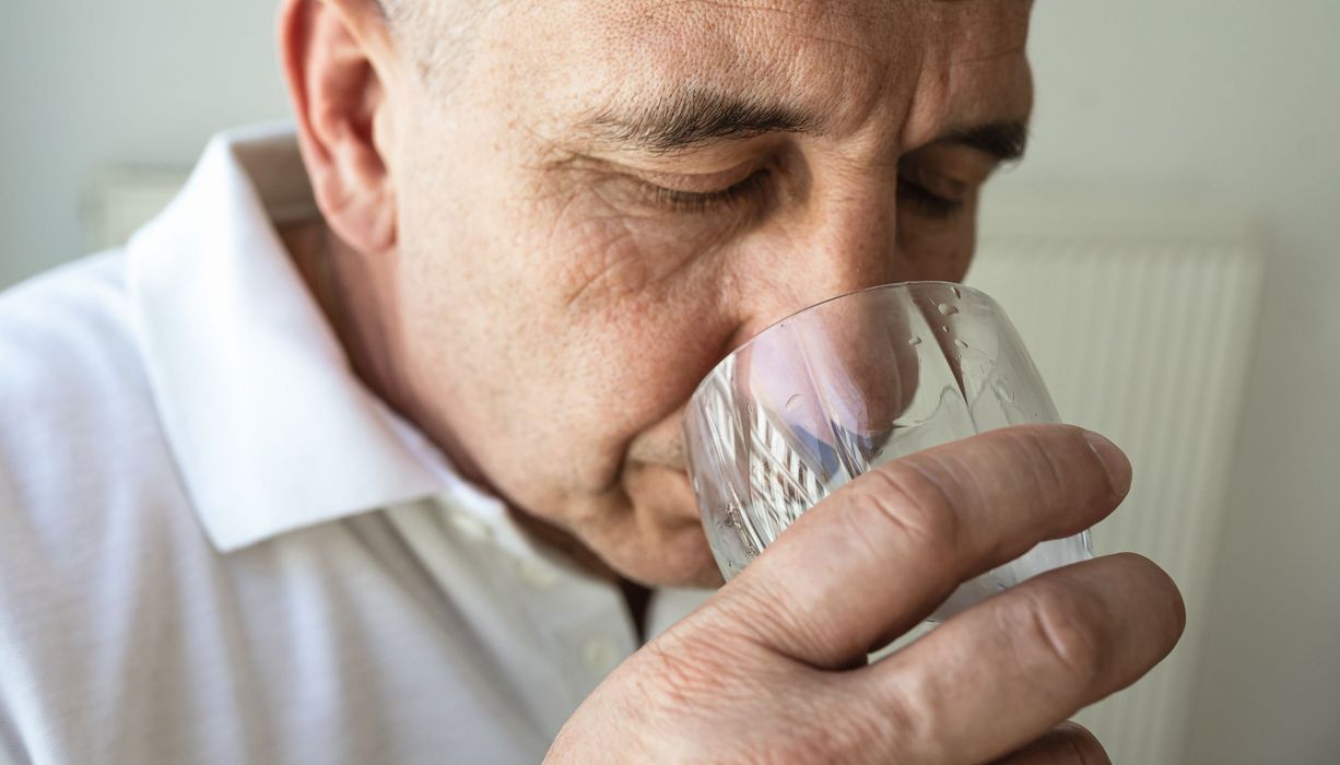 Älterer Mann, trinkt Wasser.