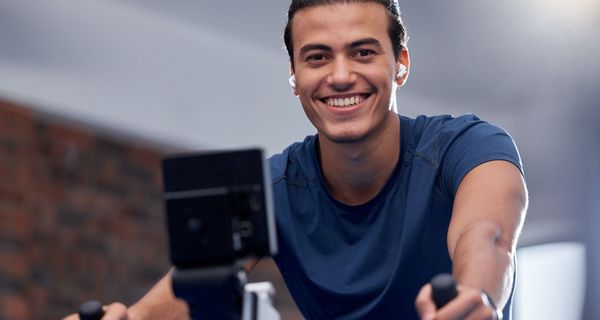 Junger Mann auf dem Hometrainer.