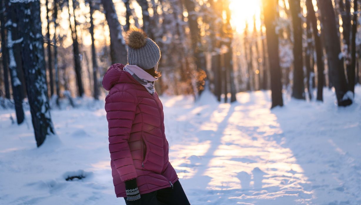 Frau, geht im Winter im Wald spazieren.