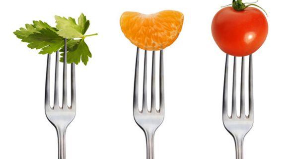 Drei Gabeln, eine spießt eine Tomate auf, die zweite ein Stück Mandarine, die dritte Blattpetersilie