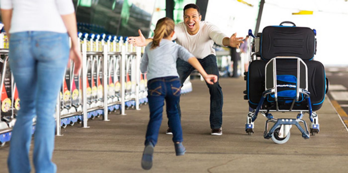 Mann  wird am Flughafen stürmisch von junger Tochter begrüßt, die in seine ausgebreiteten Arme läuft; Mutter mit dem Rücken zur Kamera am linken Bildrand