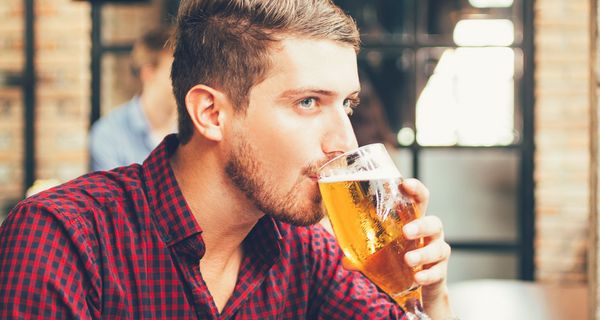 Junger Mann trinkt ein Glas Bier.