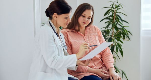 Ärztin mit übergewichtigen Patientin.