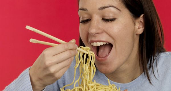 Junge Frau verschlingt eine Portion Spaghetti