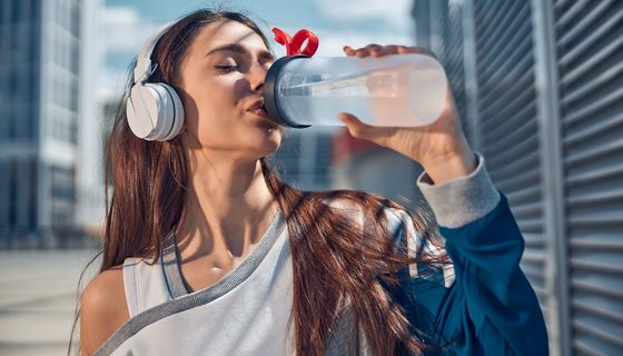 Junge Frau trinkt Wasser aus Plastikflasche