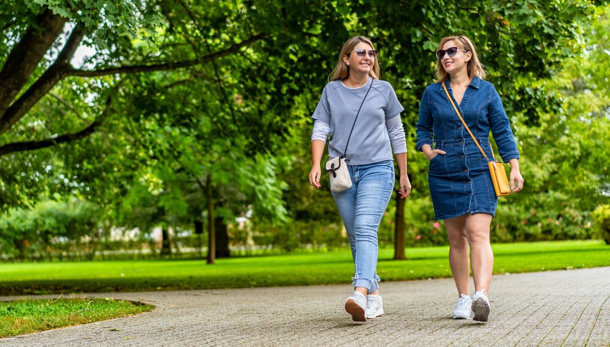 Zwei Frauen gehen im Park spazieren.