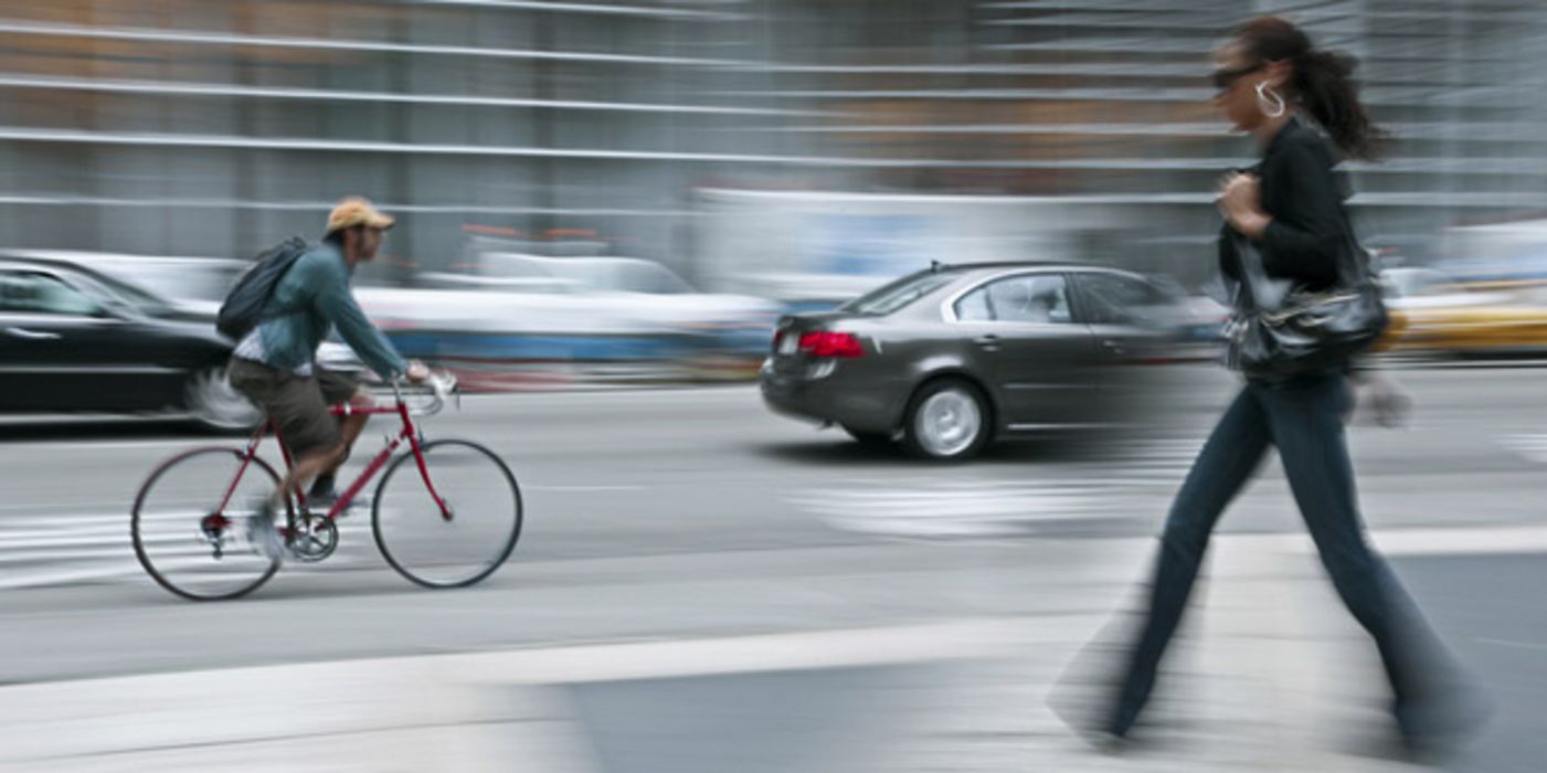 Straßenszene mit Auto, Fahrradfahrer und Fußgänger