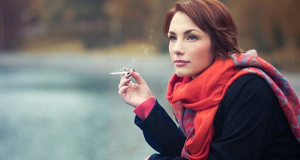 Junge Frau raucht in der Natur